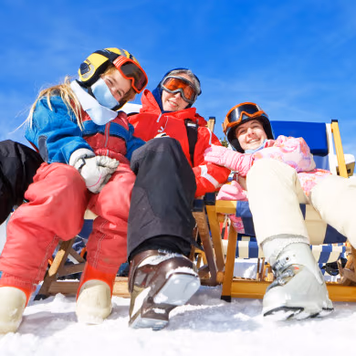 Famille en tenue de ski profitant du soleil dans un village vacances Azureva à Bussang