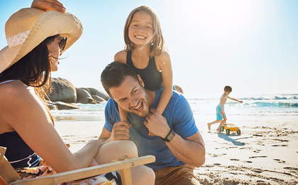 Famille souriante profitant d’une journée à la plage dans un village vacances France.