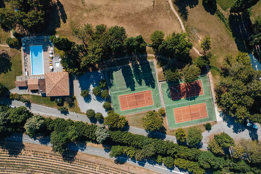 Vue aérienne du domaine Vacances Bleues à Gréoux-les-Bains avec piscine et courts de tennis entourés de verdure