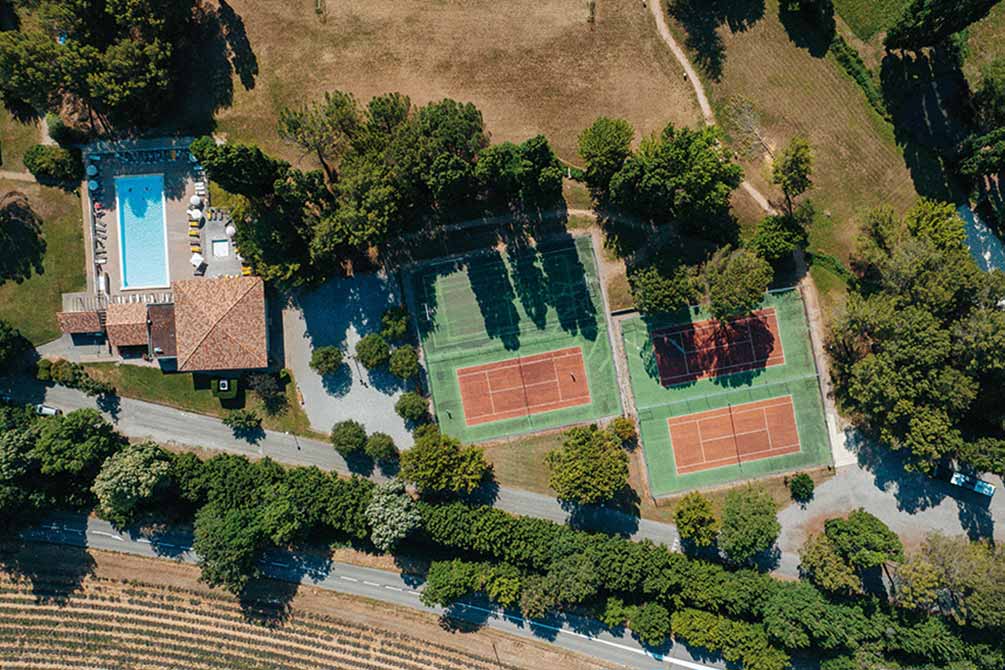 Vue aérienne du domaine Vacances Bleues à Gréoux-les-Bains avec piscine et courts de tennis entourés de verdure