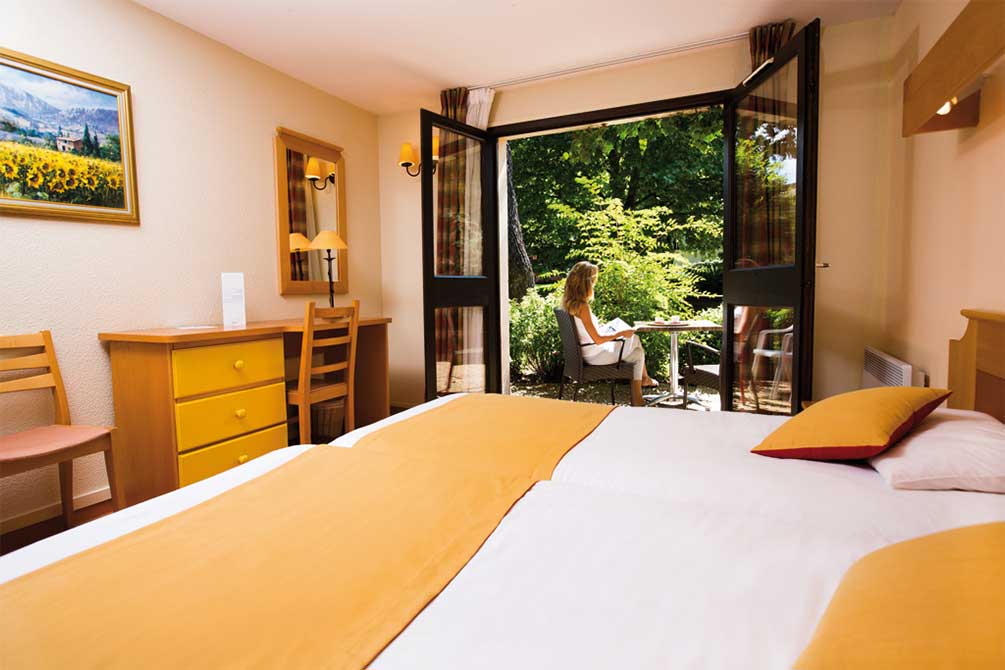 Chambre Vacances Bleues à Gréoux-les-Bains avec terrasse donnant sur un jardin verdoyant