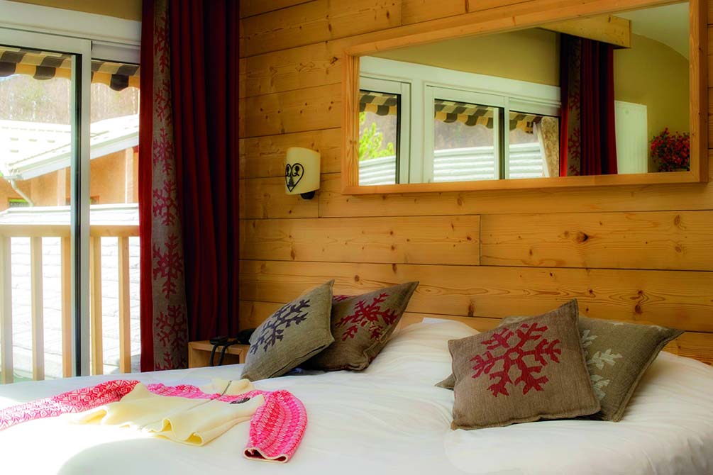 Chambre cosy en bois du village vacances Azureva avec lit double et décoration montagne