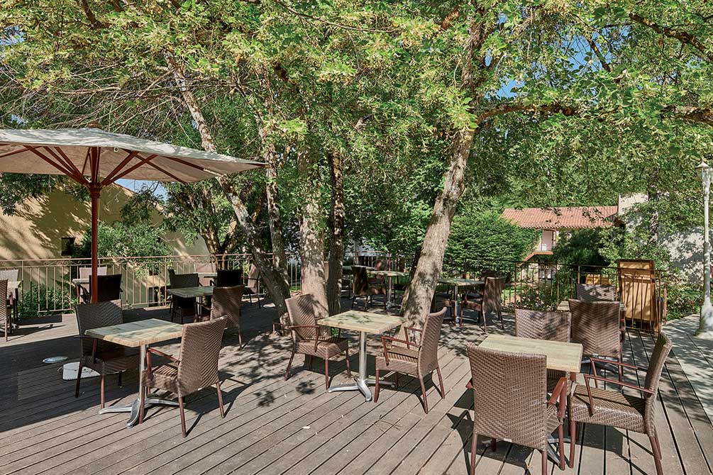 Terrasse ombragée avec tables et chaises dans un village vacances Azureva