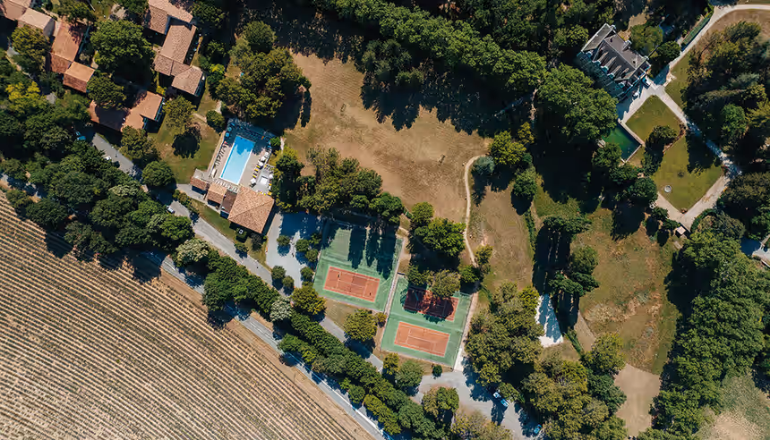 Vue aérienne du village vacances Gréoux-les-Bains avec piscine, terrains de tennis et château