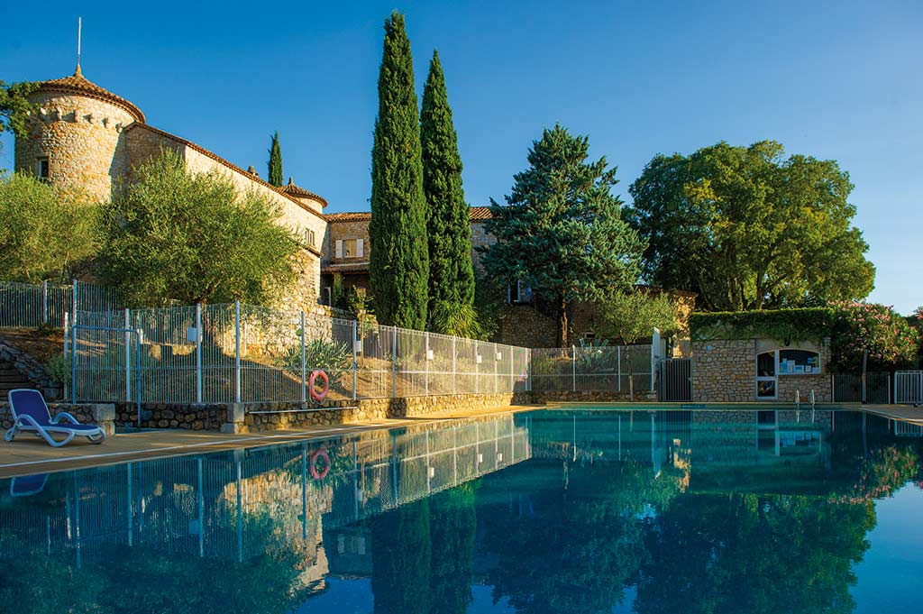 Piscine extérieure du village vacances Lou Castel en Ardèche, avec vue sur le château