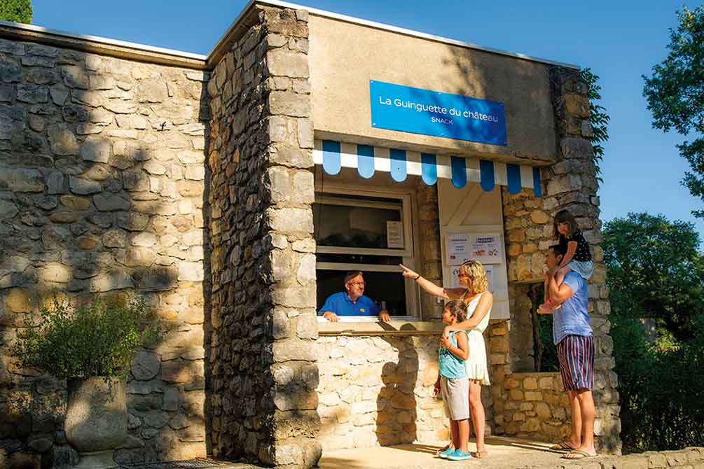 Famille commandant au snack "La Guinguette du Château" installé dans une bâtisse en pierre authentique