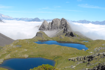 Paysage alpin avec lacs de montagne et sommets entourés de nuages