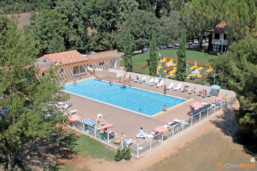 Piscine extérieure du village vacances bleu avec transats et solarium