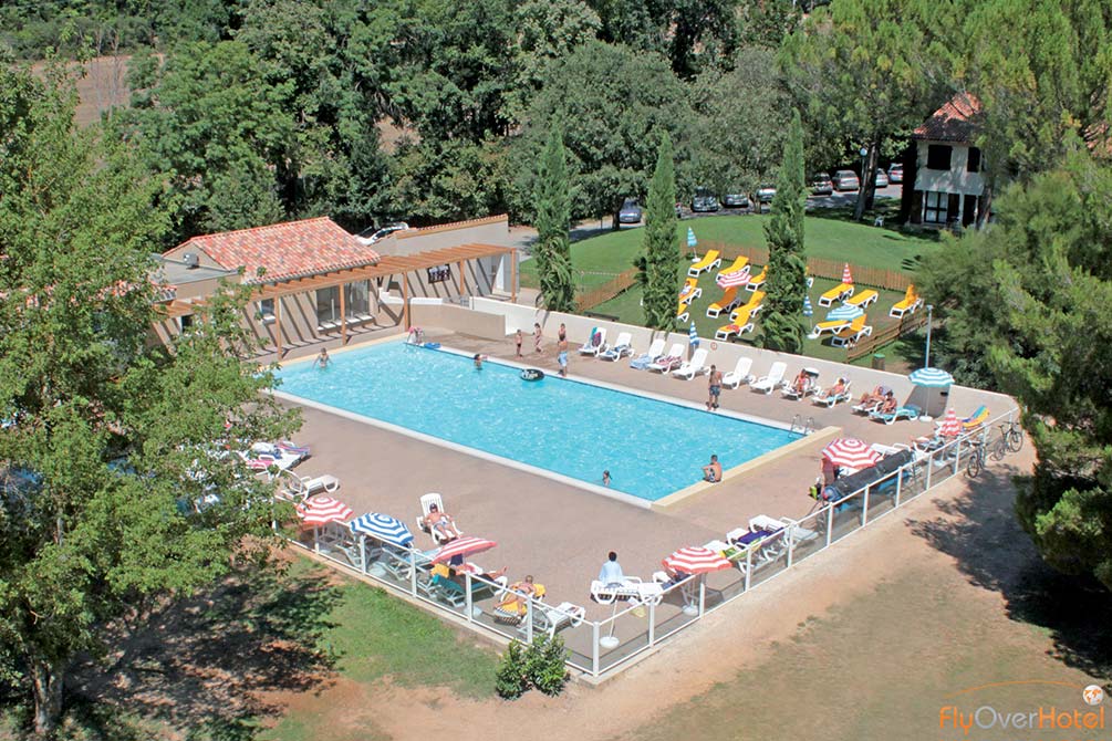 Piscine extérieure du village vacances bleu avec transats et solarium
