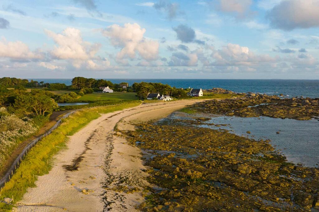 Paysage côtier de Trégunc en Bretagne Sud avec plage de sable, rochers et maisons bretonnes face à l’océan