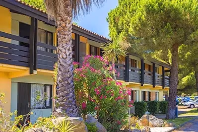 Hébergements du village vacances Azureva Cap d’Agde avec palmiers et fleurs méditerranéennes