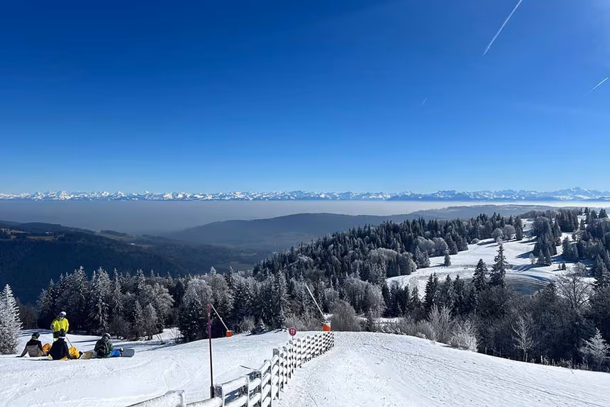 Vue panoramique sur Métabief enneigées depuis une station de ski sous un ciel bleu