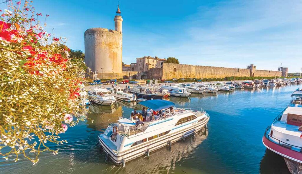 Port d'Aigues-Mortes avec Tour de Constance, remparts médiévaux et bateaux de plaisance dans le Gard en Occitanie