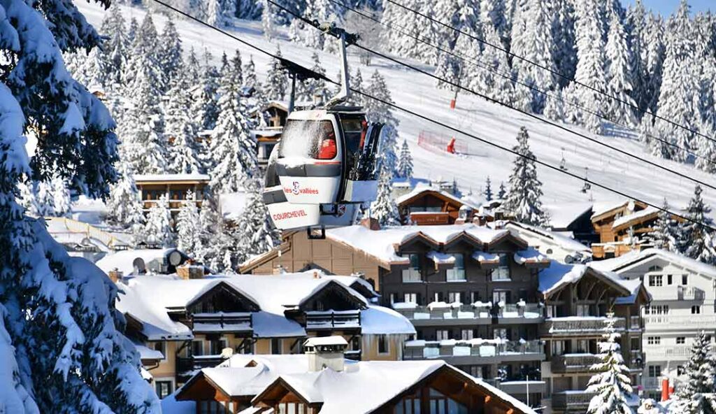 Télécabine des 3 Vallées au-dessus des chalets enneigés - Courchevel