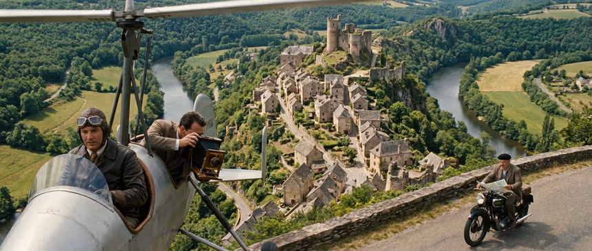 Vue aérienne ultra-réaliste du village médiéval perché de Najac dans le Kersy, avec un autogire survolant les maisons en pierre et les remparts au soleil du matin