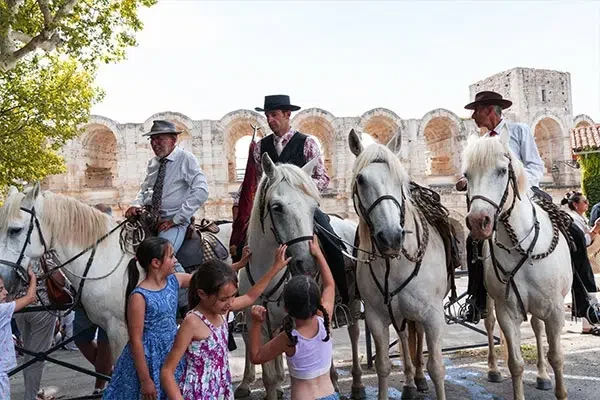a-faire-en-vacances-dans-le-Golfe-du-Lion Gardians de Camargue avec chevaux blancs devant les arènes d’Arles, tradition du Golfe du Lion