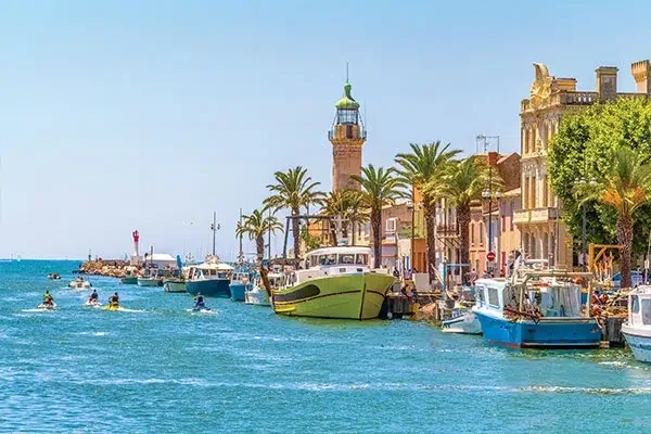 vacances-dans-le-Golfe-du-Lion-Grau-du-Roi Port du Grau-du-Roi avec ses barques de pêche et son phare en bord de mer Méditerranée en Camargue